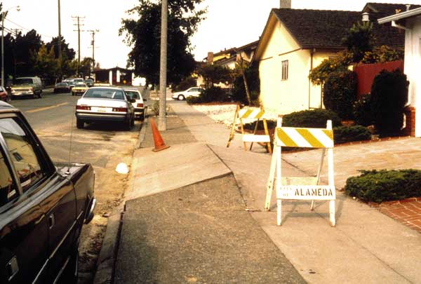 Photo of buckling of pavement in road.