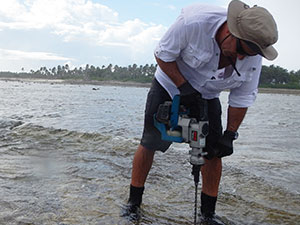 Kwajalein fieldwork: Photo of Curt Storlazzi installing wave/tide gauge mounts on the reef flat off Roi-Namur.