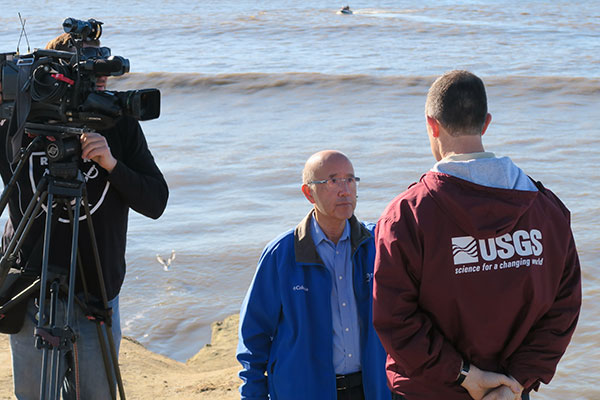 David Louie of ABC7 News interviews USGS researcher Patrick Barnard near the San Lorenzo River mouth during January 13 seafloor surveys to measure sand delivered by recent storms. Photo by Andrew Stevens, USGS.