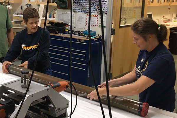 Mary McGann and Janet Watt, in the USGS core lab, cutting a core sample of mud, collected from the bottom of San Francisco Bay.