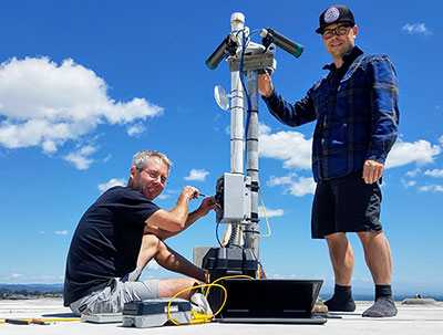 Gerry Hatcher, left, and Shawn Harrison work on their video camera station atop a hotel in Santa Cruz, California. Photo by Shawn Harrison, USGS