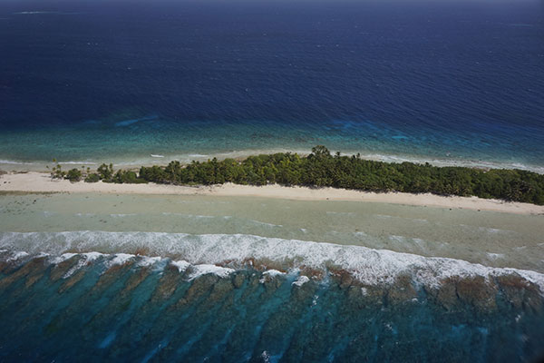 Section of Kwajalein Atoll showing narrow island surrounded by beach and coral reef.