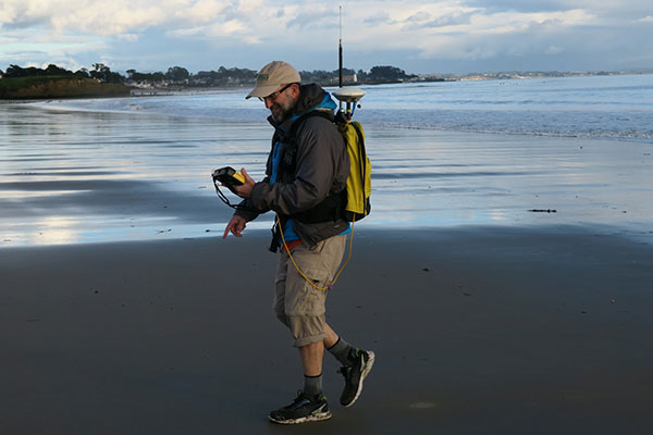 USGS oceanographer Dan Hoover uses a GPS-equipped backpack to measure sand elevations on Main Beach, Santa Cruz, near the mouth of the San Lorenzo River on January 12, 2017. Photo by Andrew Stevens, USGS.