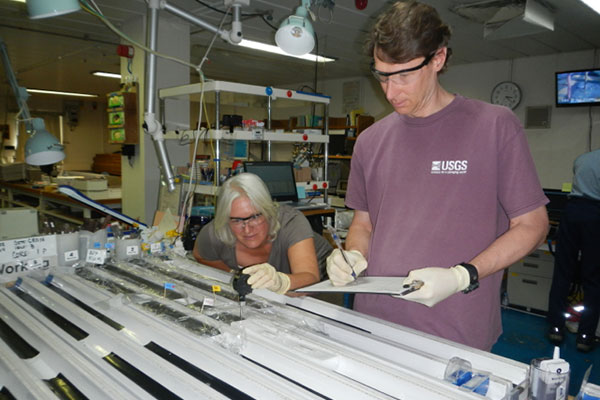 USGS Scientists Dr. Pamela Swarzenski and Dr. William Waite making measurements on sediment cores recovered from Indian Ocean during the National Gas Hydrate Program Expedition 02.