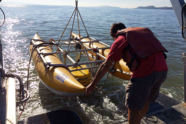 Photograph of USGS scientist deploying seismic equipment from the R/V Parke Snavely in San Pablo Bay, CA.