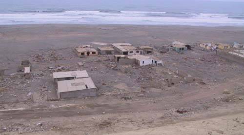 Houses on beach damaged by tsunami.