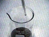 Image shows the withdrawn sample being emptied into a pre-weighed beaker.