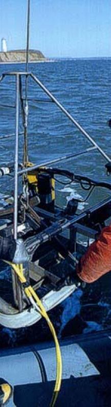 Image shows USGS and Connecticut DEP scientists deploying a modified Van Veen grab sampler in Long Island Sound. This sampler is equipped with both still and video cameras.